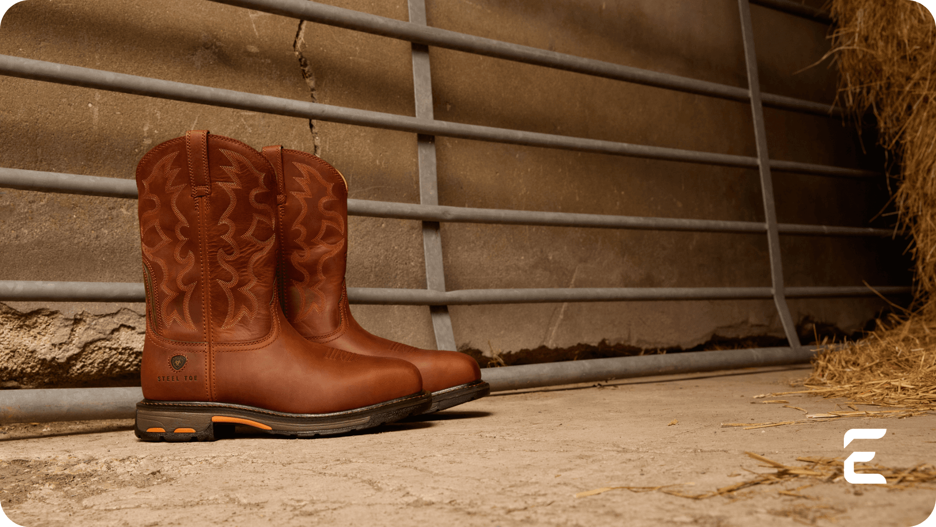 Brown leather western work boots with a safety toe, in a barn.